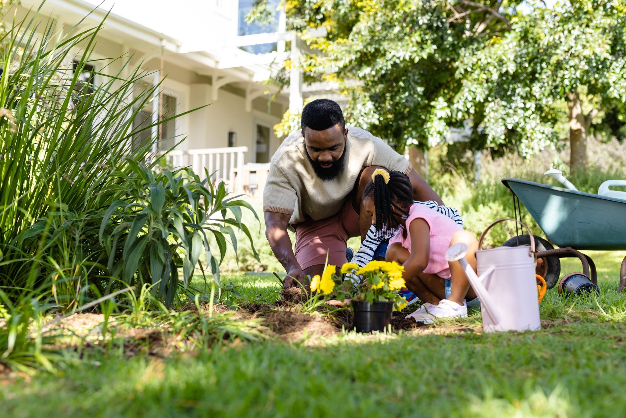Parent and child gardening outside a home
